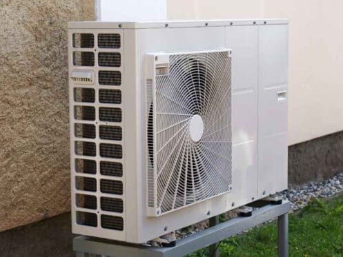 Heat pump on a stand outside a home