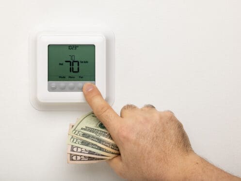 Man Adjusting Thermostat Set to Heat